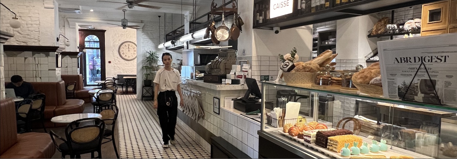 Кафе Cafeteria: официантка в зале, открытая кухня и витрина с выпечкой
